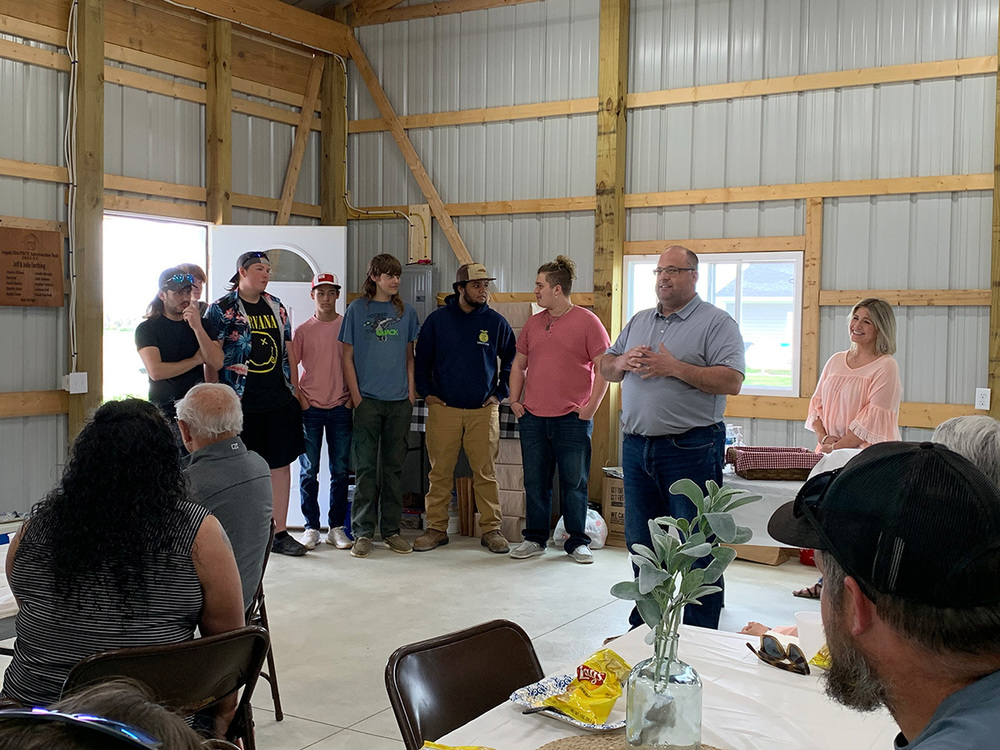 Jeff Farthing, with his wife, Julie (far right), hosted a celebration to mark the completion of the construction of their barn, built by Logan Elm students (standing, left) in Gary Mitchel’s Industrial Art class.