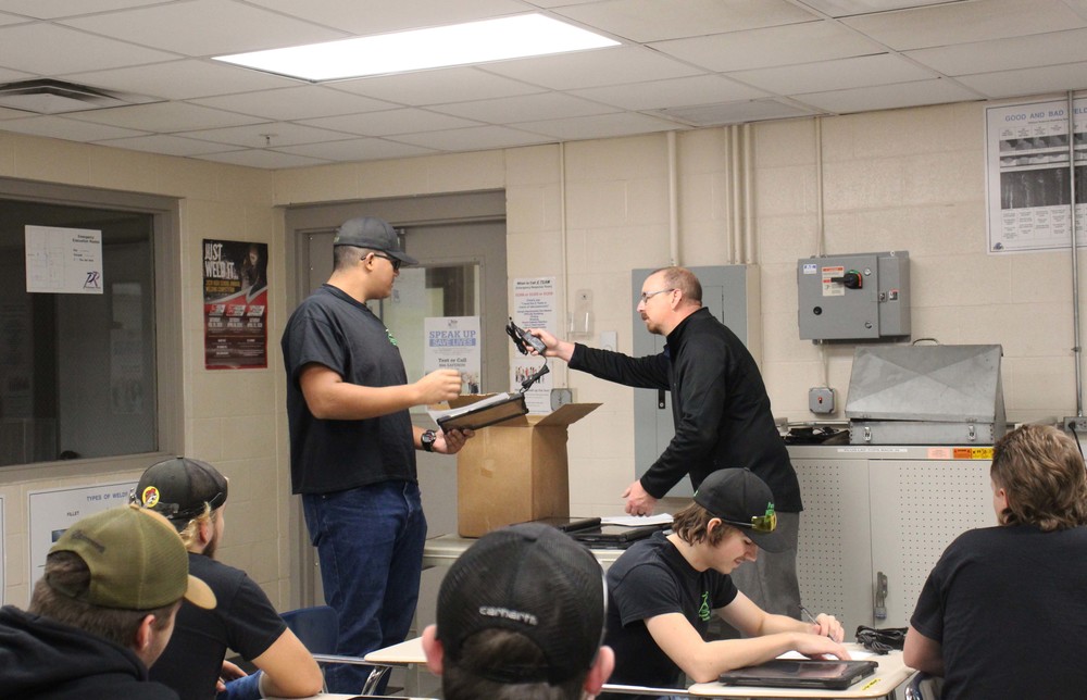 TJ  Fulgham, a senior in Precision Welding, receives his laptop from Ben Buchwalter.