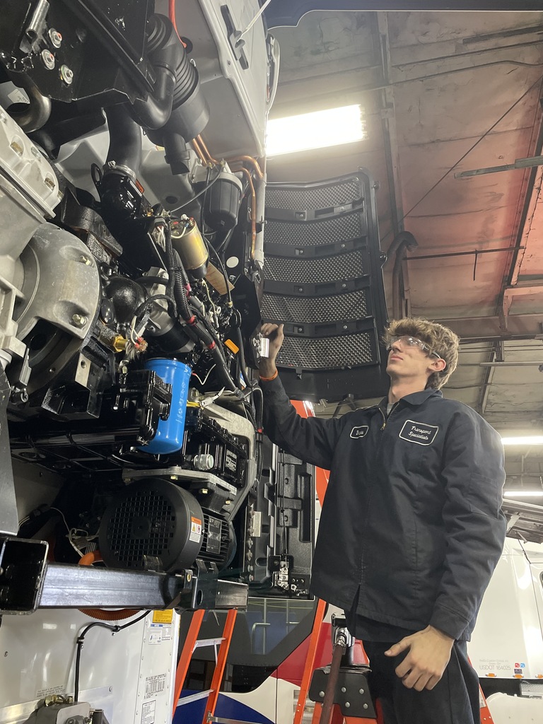 A student works on the inner workings of a semi