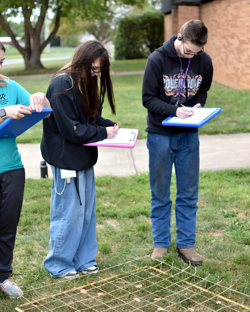 Students work on drawing the items on the survey grid.
